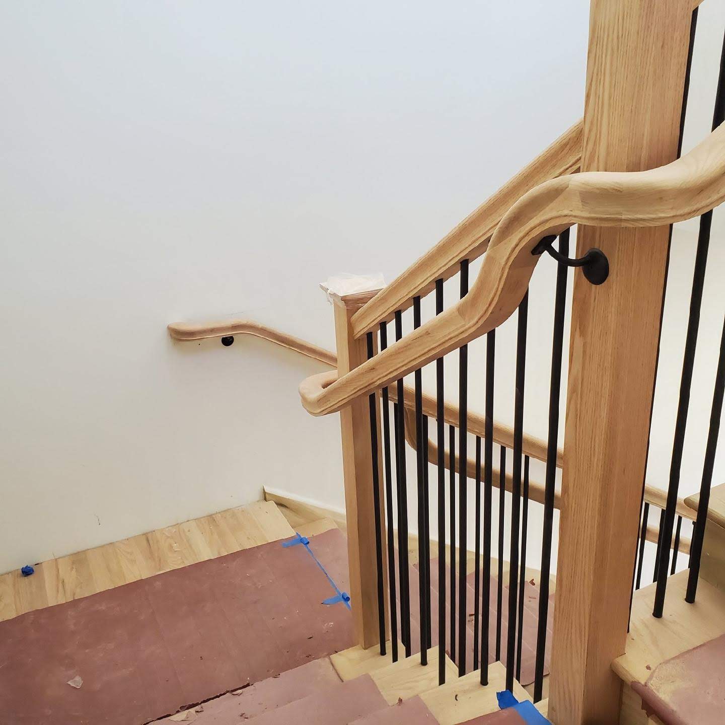 Curved oak handrail with black metal balusters